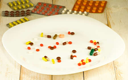 image of different pills on a plate on the tableの写真素材