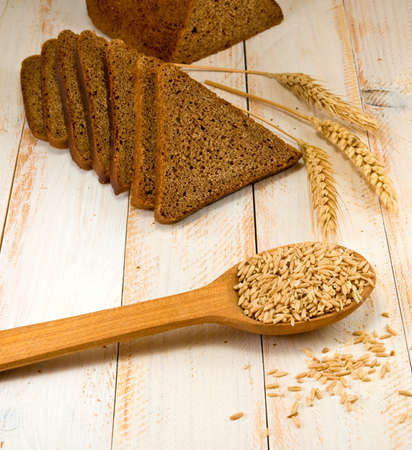 image of bread and wheat in a spoon on the wooden table