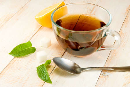 cup of tea with lemon and mint on a wooden tablの写真素材