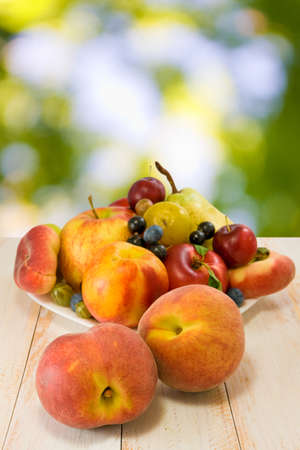 image of different fruits on a plate on a green backgroundの写真素材