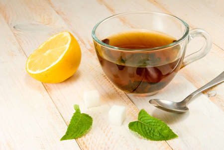 image of a cup of tea with lemon and mint on a wooden tableの写真素材