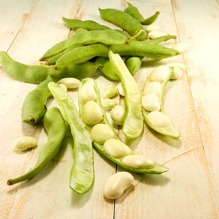 image  of beans in pods on a wooden table