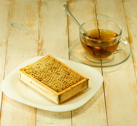image of a cup of tea and honeycomb on a plateの写真素材
