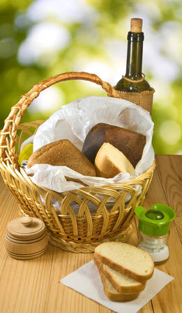 basket with bread and a bottle of wine closeupの写真素材