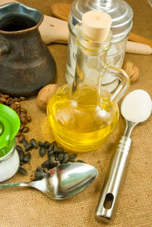image of spoons, nuts, seeds,butter, salt shaker, coffee beans, a cup on a green backgroundの写真素材