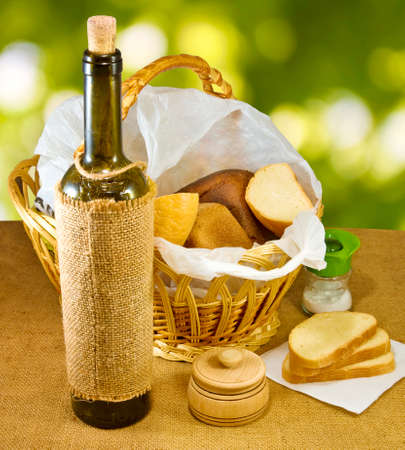 image of a basket with bread and a bottle of wine closeupの写真素材