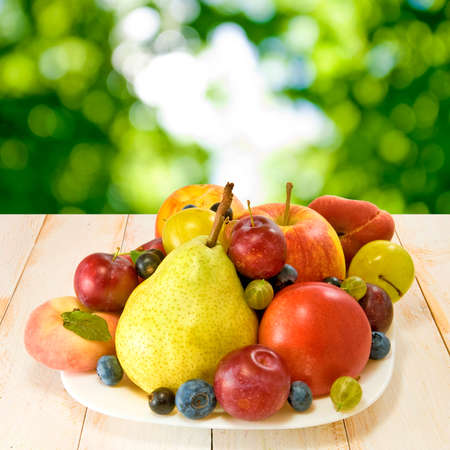 various ripe fruits on a plate on a blurred backgroundの写真素材