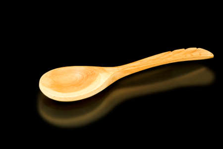 image of a wooden spoon on a black background closeupの写真素材