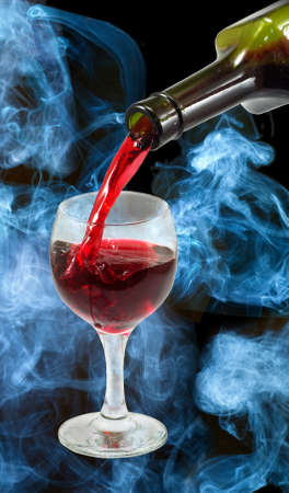 glass of wine and a bottle on smoke backgroundの写真素材