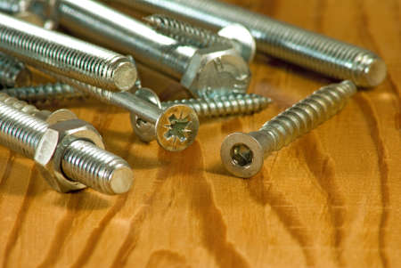 image of bolts on a wooden board close-up