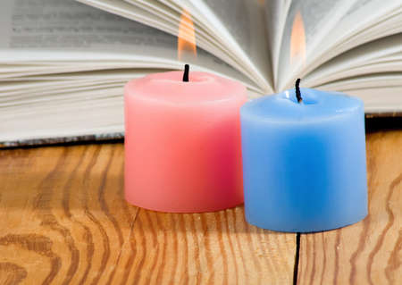 two candles on open book backgroundの写真素材