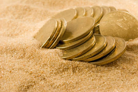 image of coins on the sand closeupの写真素材