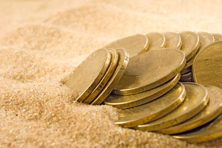 image of coins on the sand closeupの写真素材