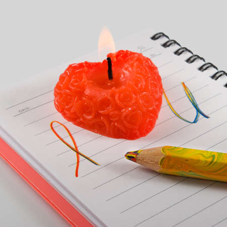 notebook with the inscription and red candle close-upの写真素材