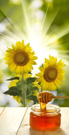 image of honey on the table against flowers background close upの写真素材