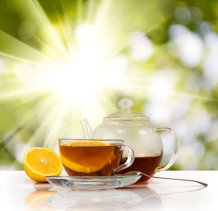 image of cups with tea and lemon on sunlight backgroundの写真素材