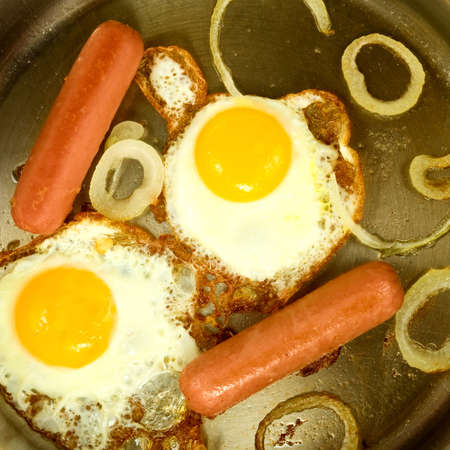 image of fried eggs and sausage on frying pan close upの写真素材
