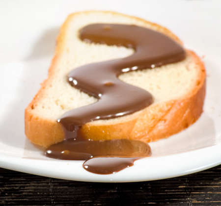 slice of white bread watered with liquid chocolate closeupの写真素材