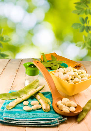 image of beans in pods on a wooden table close-upの写真素材
