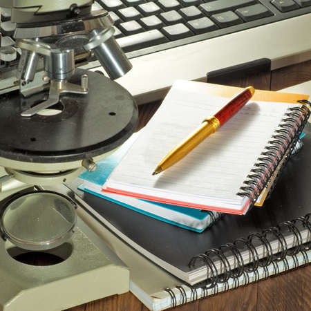 image of keyboard ,microscope, notebook and pen close-upの写真素材