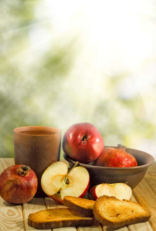 apple, pomegranate, crackers on table against  sun raysの写真素材