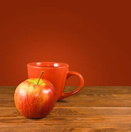image of apple and cup on wooden table close upの写真素材