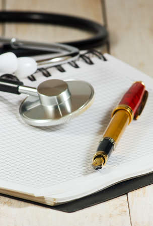 image of stethoscope, notebooks and pen on white backgroundの写真素材