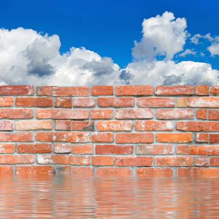 Image of a brick wall in the water against a background of the sky close upの写真素材