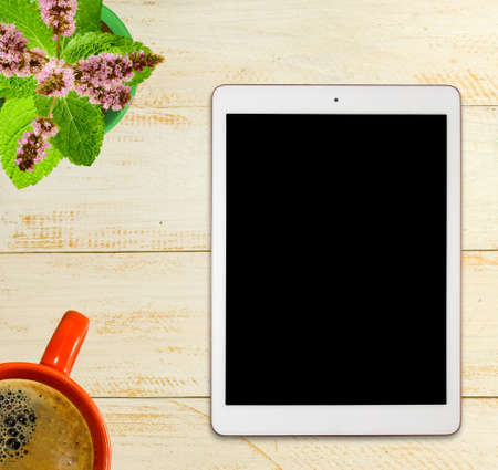 image of a cup with coffee, a plate and a flower on a wooden table