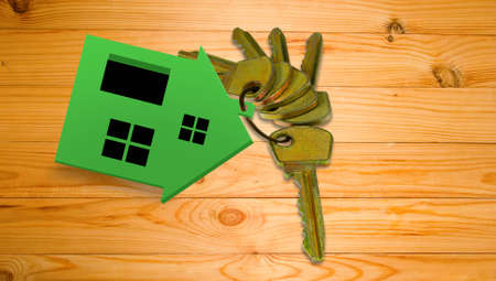 miniature house and keys on a wooden board