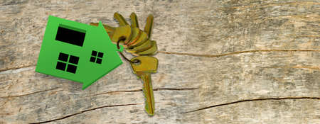 miniature house and keys on a wooden boardの写真素材