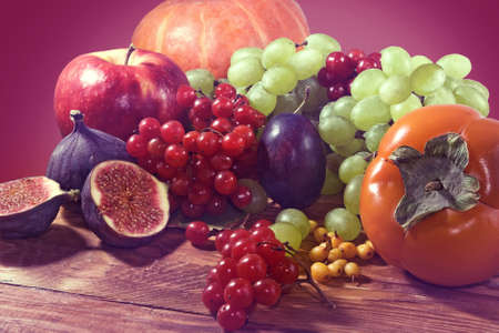 Toned image of various ripe fruits on red background close-up