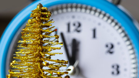 Image of a New Year's toy close-up on the background of the clock. Toy fir tree close-up