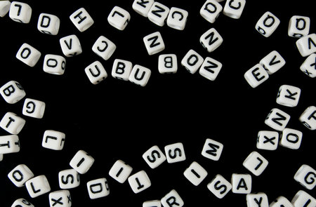 Image of cubes with letters of the alphabet printed on them on a black background