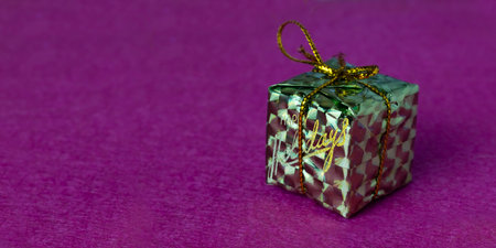 Image of a toy box on a purple surface. Happy holidays is written on the box.