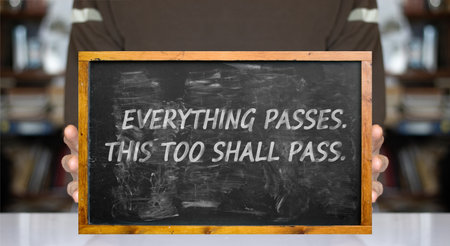 A blackboard in a reduced version is held in hands. Chalk marks on the blackboard. Quote from Seneca's letters: Nothing is ours, except timeの写真素材