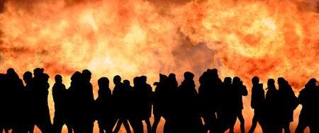Image of black silhouettes of many people against the background of a solid wall of fireの写真素材
