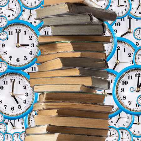 Image of a stack of books against a background of many clock dialsの写真素材