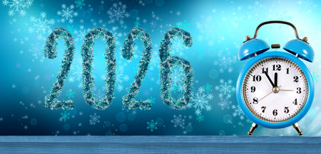 Bright blue decorations of the year 2026 stand out against a winter backdrop, with a classic clock showing time, symbolizing the countdown to the New Year.の写真素材