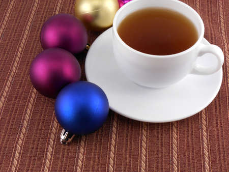 tea white cup and christmas baubles, holiday conceptの写真素材