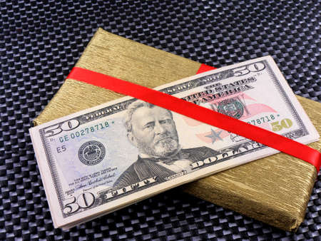 Money on red bow decorated gift boxの写真素材