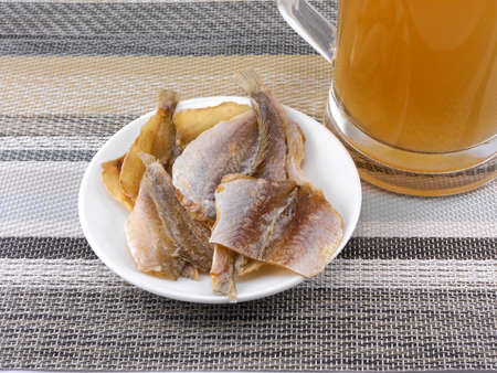 smoked fish and cup of beer on a background