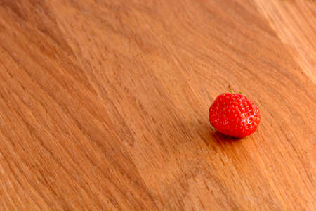 close up of small strawberry on woodの写真素材