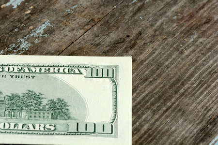 Close-up of a $100 banknotes on wooden backgroundの写真素材