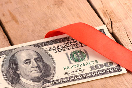 One Hundred Dollar Bills Wrapper in Red Ribbonの写真素材