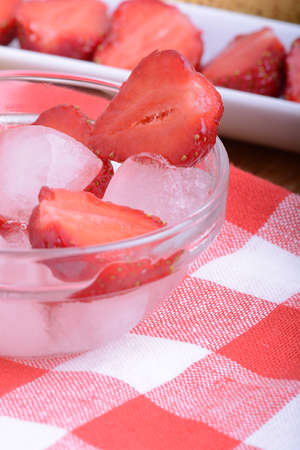 A slice of red strawberry on glass plate in party theme backgroundの写真素材