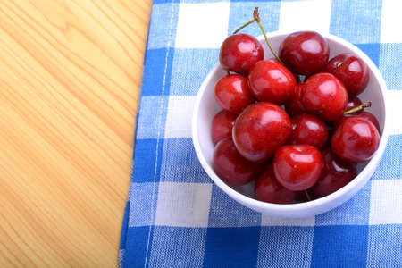 Red ripe cherries in a white bowlの写真素材