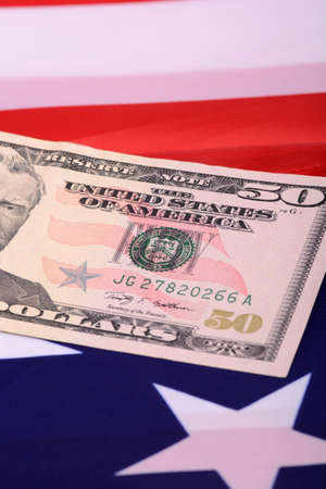 fifty dollar bill in front of the American flagの写真素材