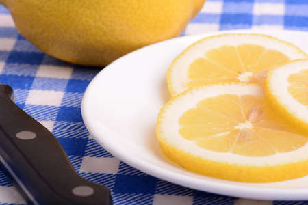 Halved lemon and a knife on a white plateの写真素材