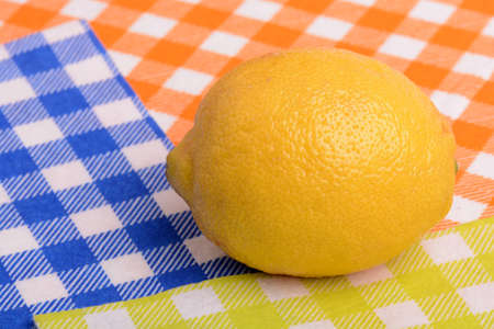 Fresh whole lemon on yellow blue and orange backgroundの写真素材